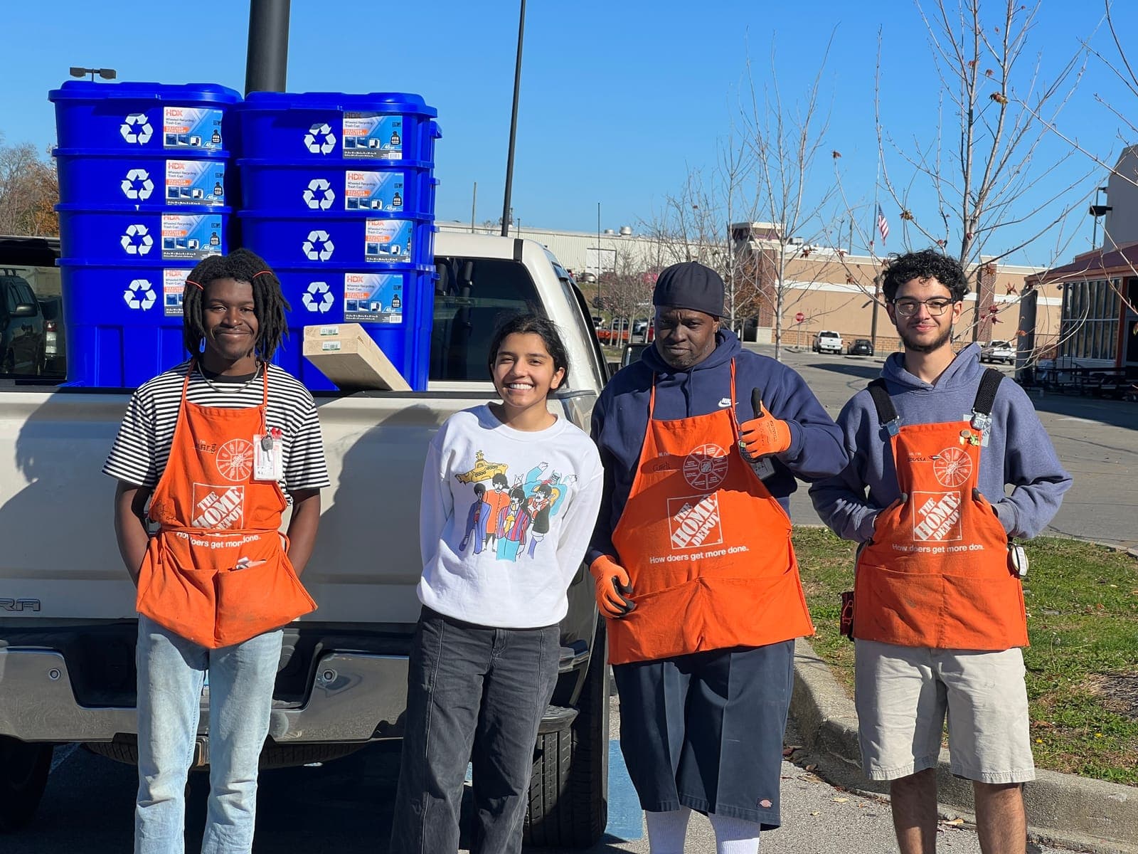 Student volunteers in Home Depot aprons picking up recycling bins to deploy across Pike County high schools
