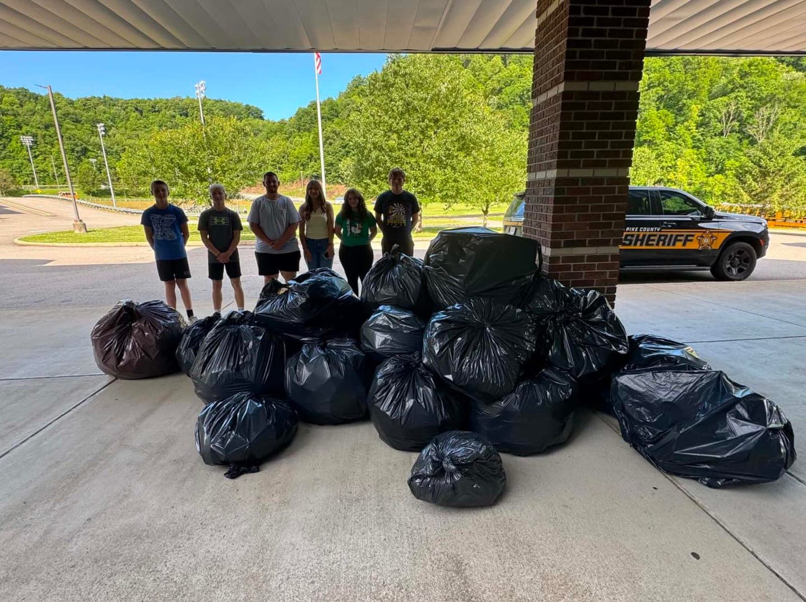 Student volunteers collecting waste and partnering with the local community.