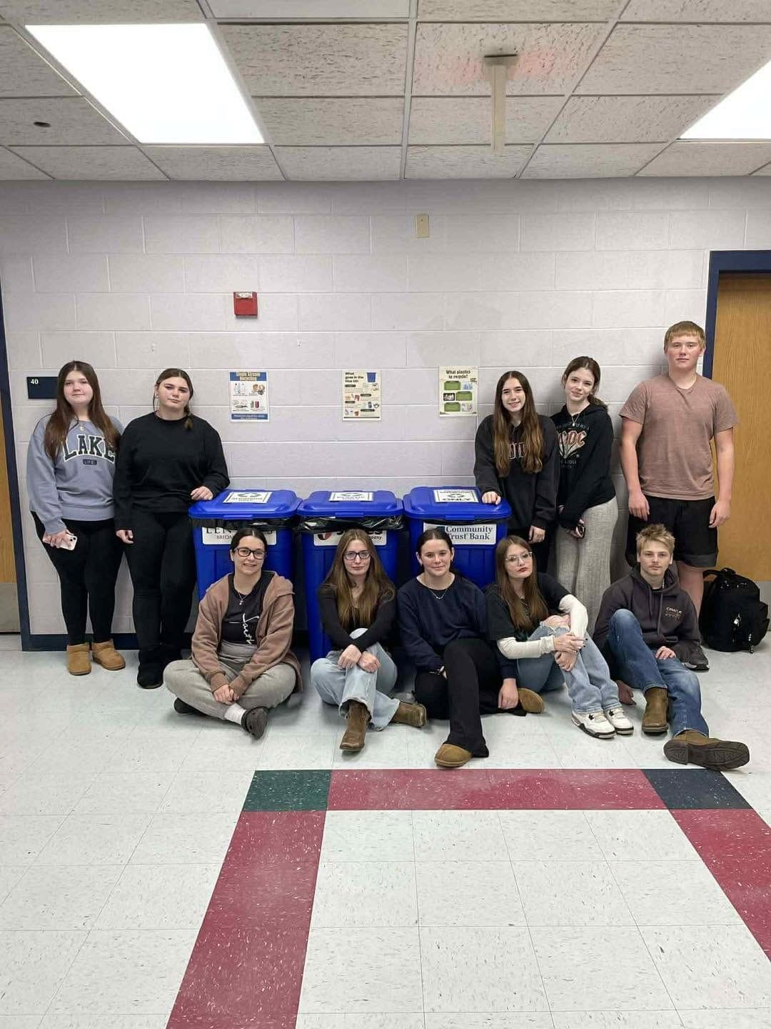 Student volunteers with installed, labeled recycling bins in a Pike County high school